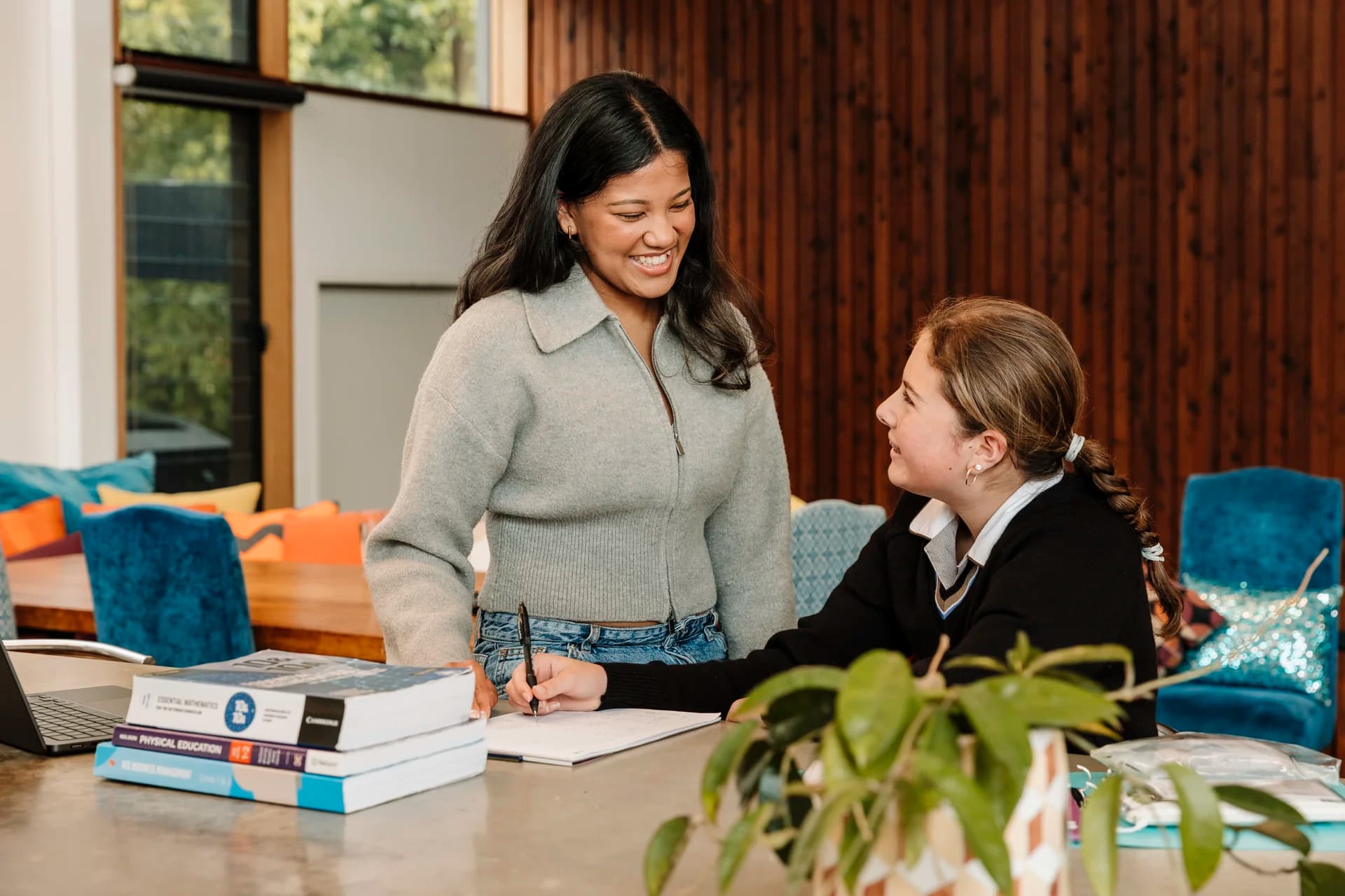 A TMJ tutor working with a student at a desk