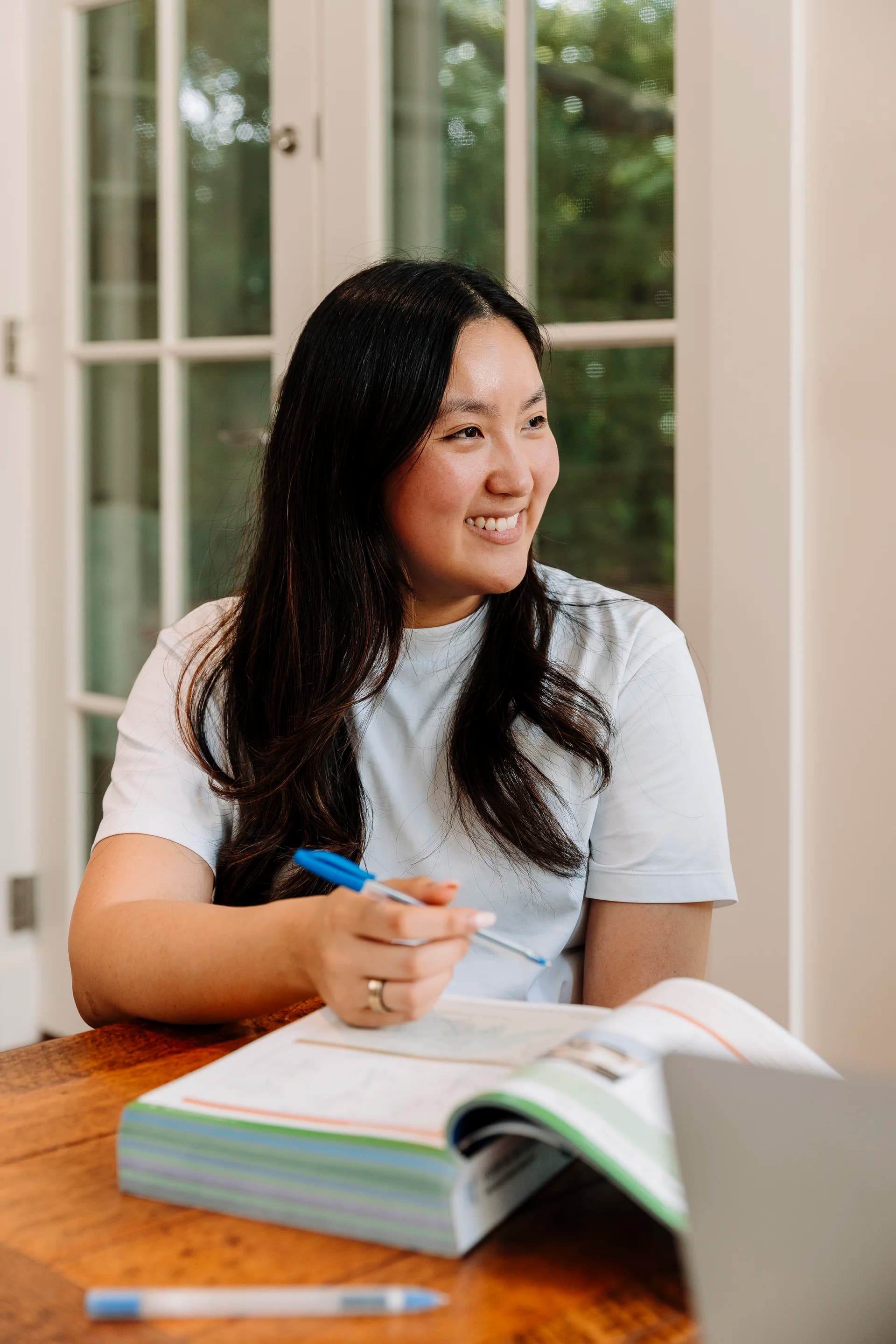 A TMJ tutor at a desk, smiling and ready to support a student